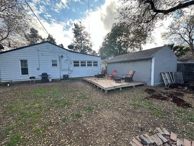 back of property featuring a deck and a shed