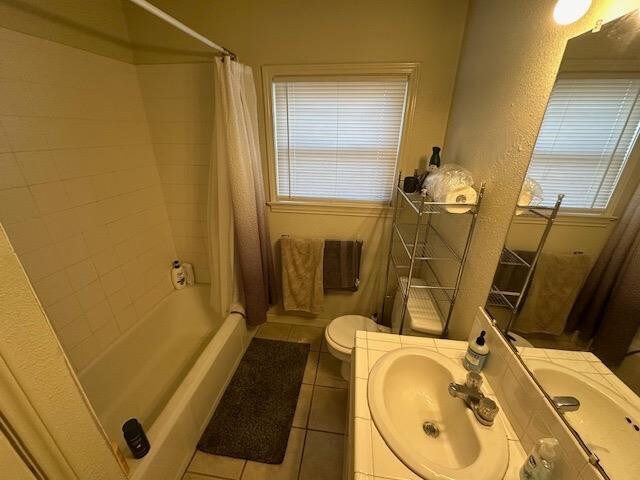 bathroom featuring vanity, toilet, tile patterned flooring, and a wealth of natural light