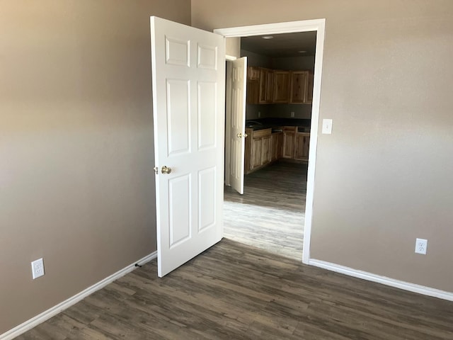 corridor with dark hardwood / wood-style flooring