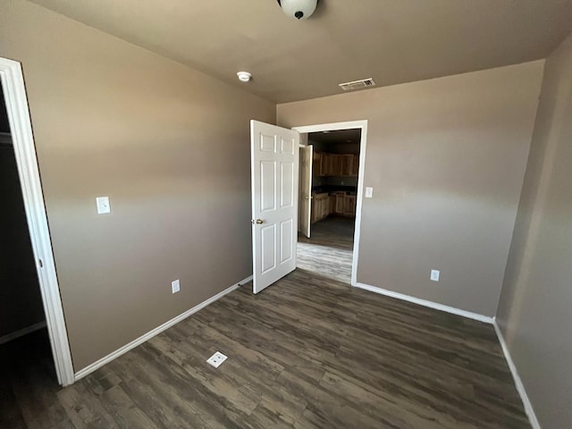 unfurnished bedroom featuring dark hardwood / wood-style flooring