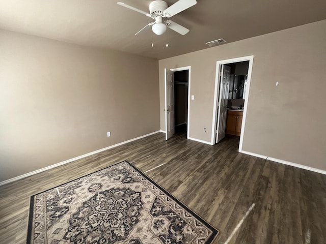 unfurnished bedroom featuring ceiling fan, connected bathroom, and dark hardwood / wood-style flooring