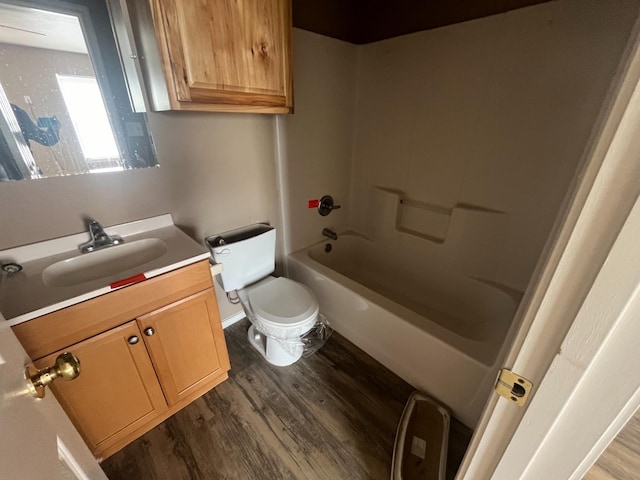 full bathroom featuring hardwood / wood-style flooring, vanity, washtub / shower combination, and toilet