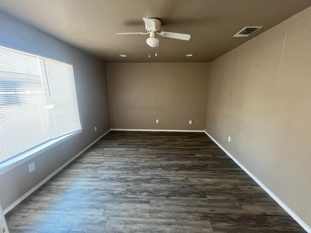 empty room with dark hardwood / wood-style floors and ceiling fan