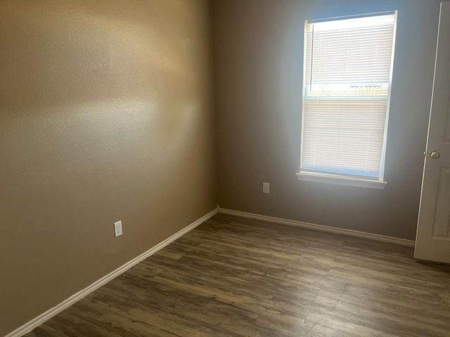 unfurnished room featuring dark wood-type flooring