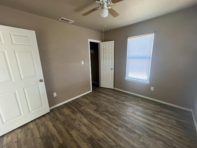 unfurnished bedroom featuring ceiling fan and dark hardwood / wood-style flooring