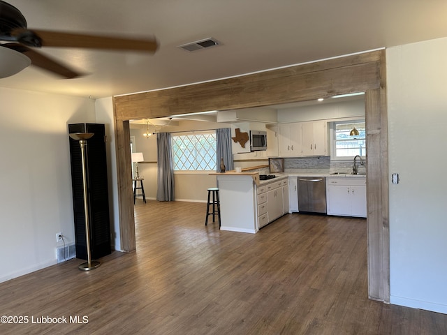 2326 58th St, Lubbock, TX 79412 - kitchen with stainless steel appliances, ceiling fan, white cabinetry, and dark wood-type flooring