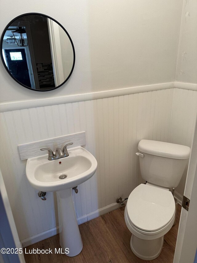 2326 58th St, Lubbock, TX 79412 - bathroom with wood finished floors and a wainscoted wall