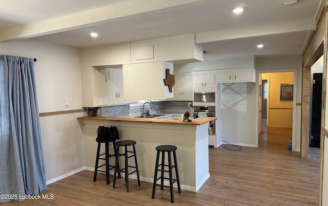 2326 58th St, Lubbock, TX 79412 - kitchen with oven, wood counters, dark wood-type flooring, a peninsula, and recessed lighting