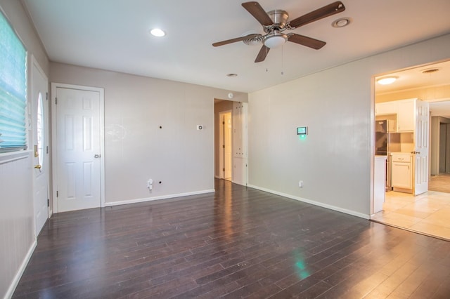 empty room with dark hardwood / wood-style floors and ceiling fan