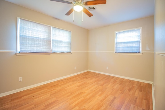 empty room with ceiling fan and light hardwood / wood-style floors