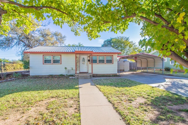 view of front of home with a front lawn and a carport