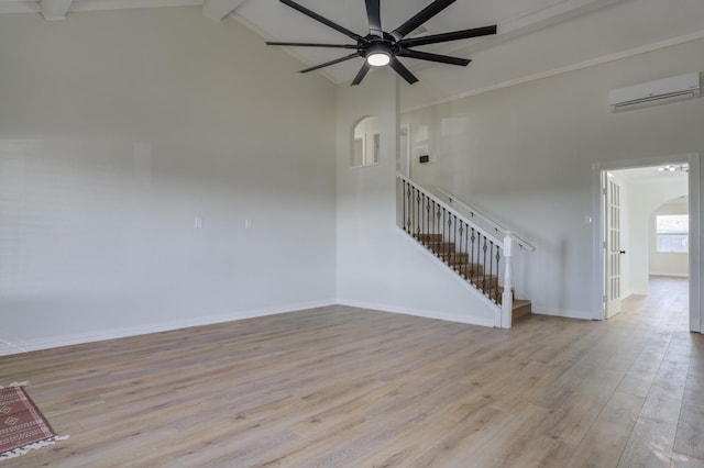 interior space featuring ceiling fan, lofted ceiling with beams, light hardwood / wood-style floors, and a wall mounted AC