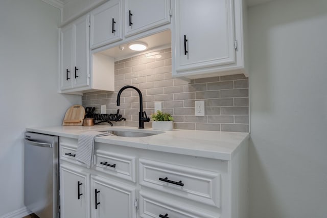 kitchen with sink, dishwasher, tasteful backsplash, light stone counters, and white cabinets