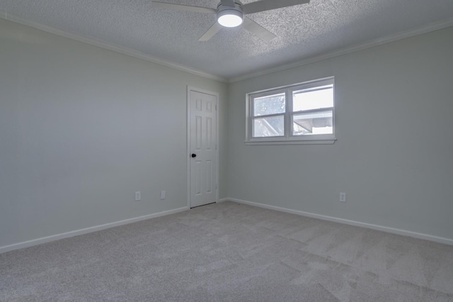 carpeted spare room with ceiling fan, ornamental molding, and a textured ceiling