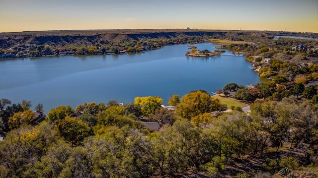 aerial view at dusk featuring a water view