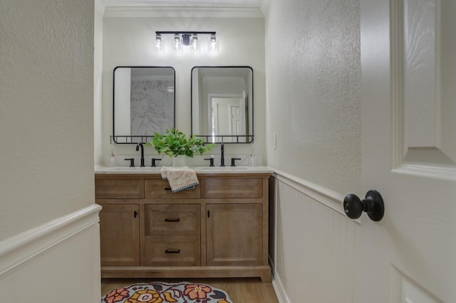 bathroom featuring vanity, ornamental molding, and hardwood / wood-style floors