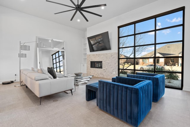 living room featuring ceiling fan and a fireplace