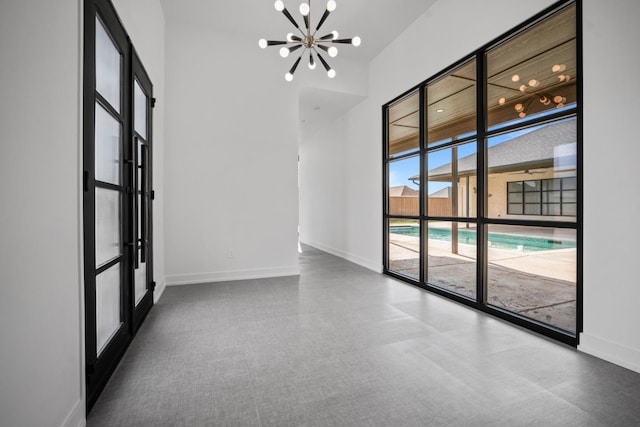 unfurnished room featuring a chandelier