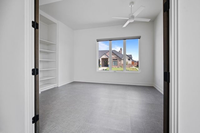 unfurnished room with built in shelves and ceiling fan