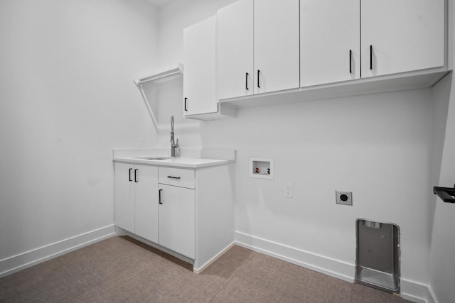 clothes washing area with hookup for a washing machine, sink, hookup for an electric dryer, and cabinets