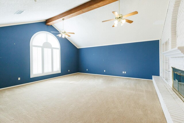 unfurnished living room featuring ceiling fan, vaulted ceiling with beams, a fireplace, a textured ceiling, and light carpet