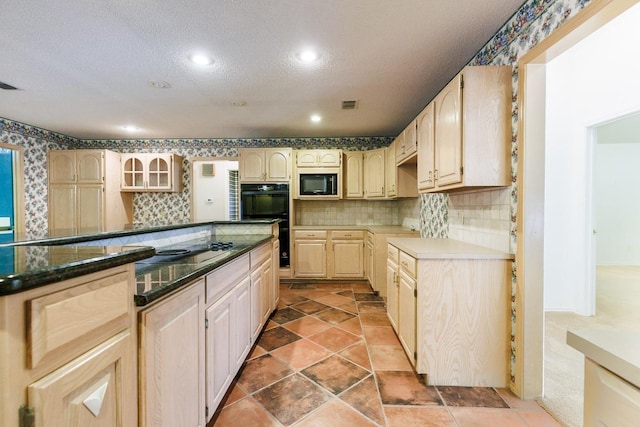 kitchen featuring backsplash, black appliances, a textured ceiling, and light brown cabinets