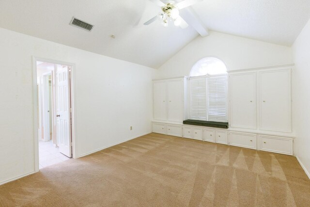 unfurnished bedroom featuring connected bathroom, vaulted ceiling with beams, light carpet, and ceiling fan