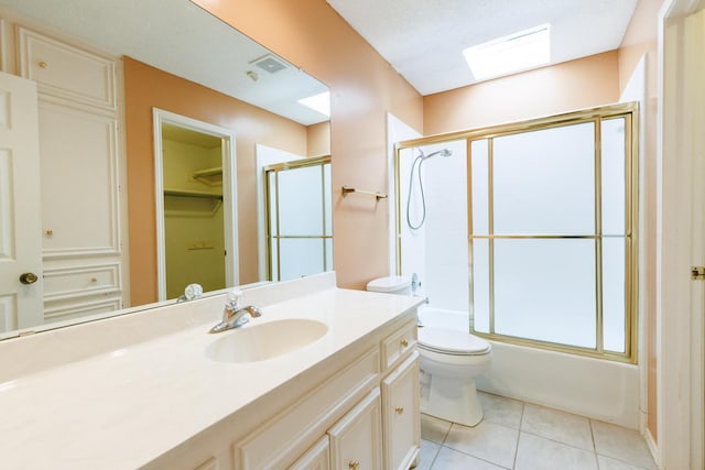 full bathroom featuring vanity, tile patterned floors, shower / bath combination with glass door, and toilet