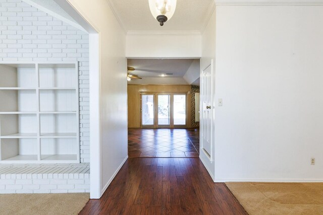 corridor with crown molding, built in features, and dark hardwood / wood-style floors