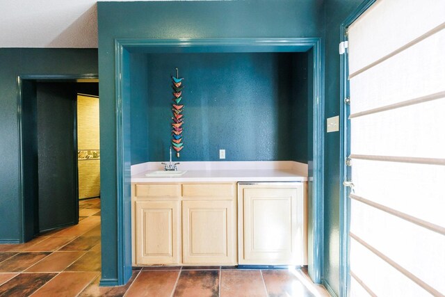 bar featuring sink and dark tile patterned floors