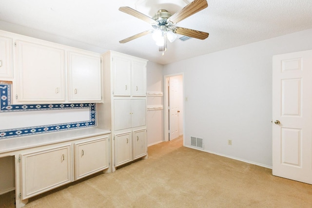 interior space with light carpet and ceiling fan