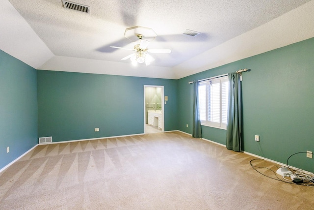 carpeted empty room featuring lofted ceiling, a textured ceiling, and ceiling fan