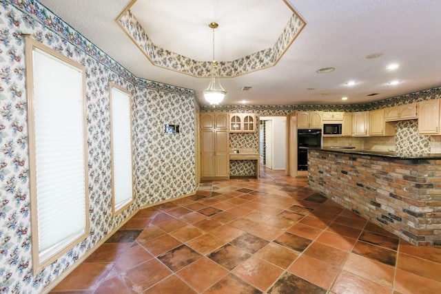 interior space featuring decorative light fixtures, a raised ceiling, and black appliances