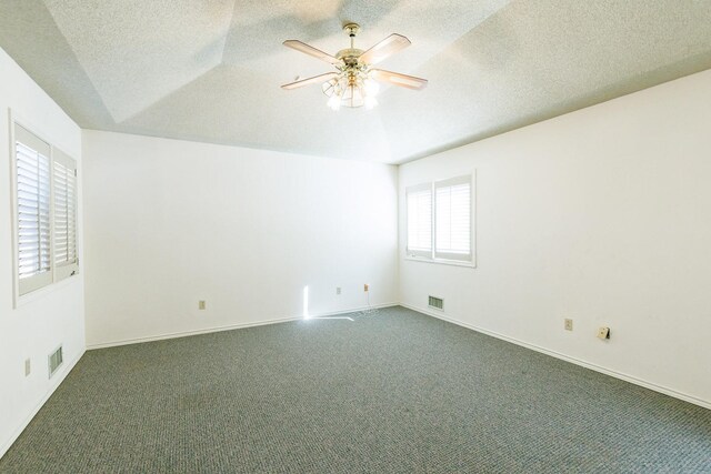 carpeted spare room with a textured ceiling and ceiling fan