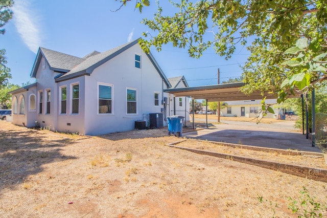 rear view of house with cooling unit and a carport