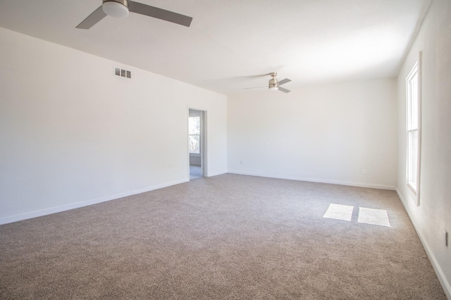 carpeted spare room featuring ceiling fan