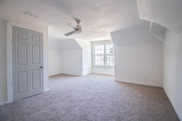 additional living space featuring ceiling fan, carpet floors, and vaulted ceiling