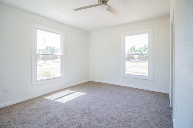 empty room with plenty of natural light, carpet floors, and ceiling fan