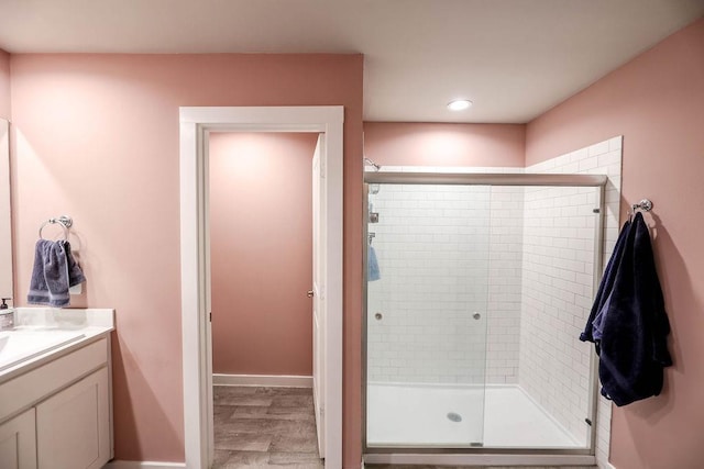 bathroom featuring a shower with door, vanity, and hardwood / wood-style flooring