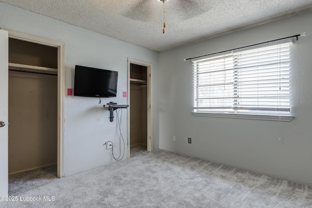 3312 86th St, Lubbock, TX 79423 - unfurnished bedroom featuring a textured ceiling, carpet floors, multiple closets, and a ceiling fan