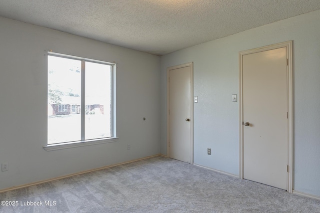 3312 86th St, Lubbock, TX 79423 - unfurnished bedroom with multiple windows, a textured ceiling, and carpet floors