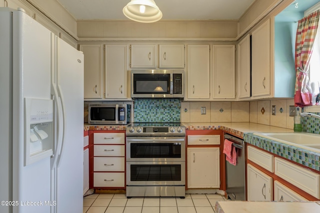 3312 86th St, Lubbock, TX 79423 - kitchen with appliances with stainless steel finishes, light tile patterned floors, tasteful backsplash, light countertops, and a sink