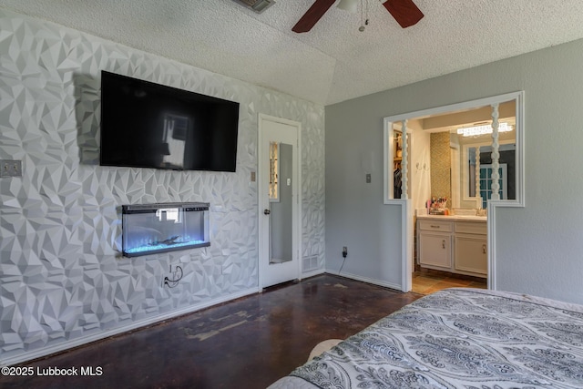 3312 86th St, Lubbock, TX 79423 - bedroom with a textured ceiling, ensuite bathroom, ceiling fan, and a glass covered fireplace