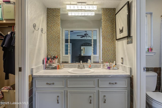 3312 86th St, Lubbock, TX 79423 - bathroom with vanity, toilet, ceiling fan, a textured ceiling, and a closet