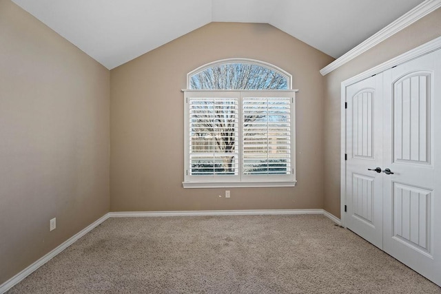 carpeted empty room featuring vaulted ceiling and a healthy amount of sunlight