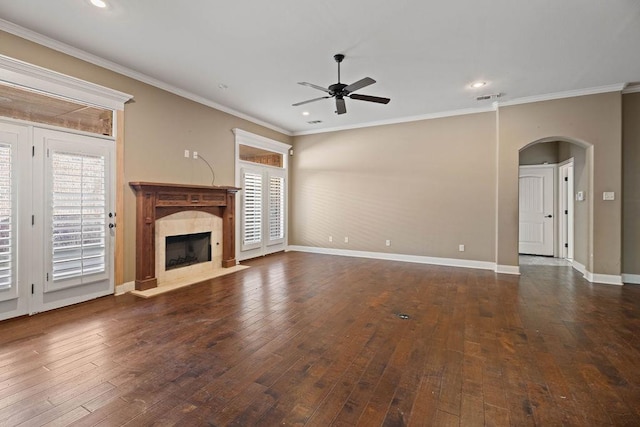 unfurnished living room with a fireplace, crown molding, dark wood-type flooring, and a healthy amount of sunlight