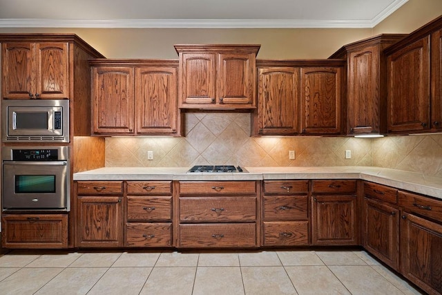 kitchen featuring ornamental molding, appliances with stainless steel finishes, decorative backsplash, and light tile patterned floors