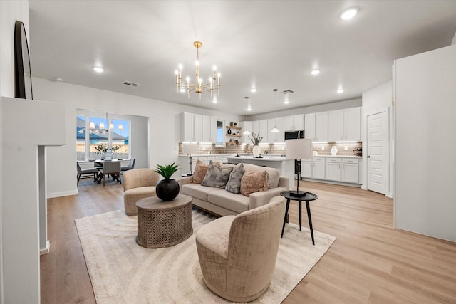 unfurnished living room featuring light hardwood / wood-style flooring, a notable chandelier, and a fireplace