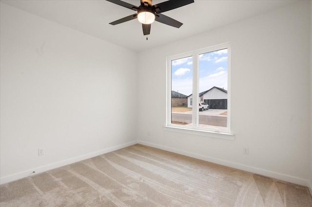 carpeted spare room with ceiling fan