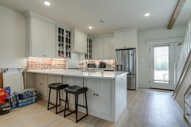 3713 128th St, Lubbock, TX 79423 - kitchen featuring stainless steel fridge with ice dispenser, decorative backsplash, a peninsula, light wood-style flooring, and recessed lighting